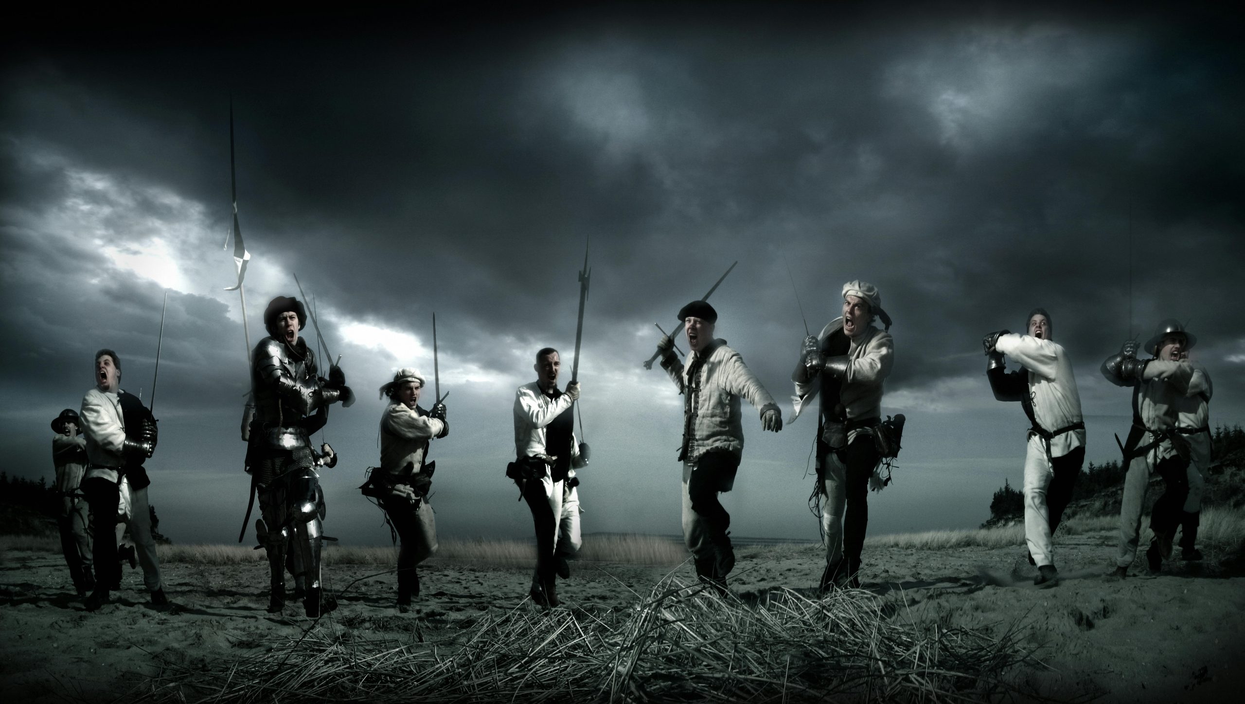 Dramatic scene of medieval knights charging in a reenactment battle under stormy skies.