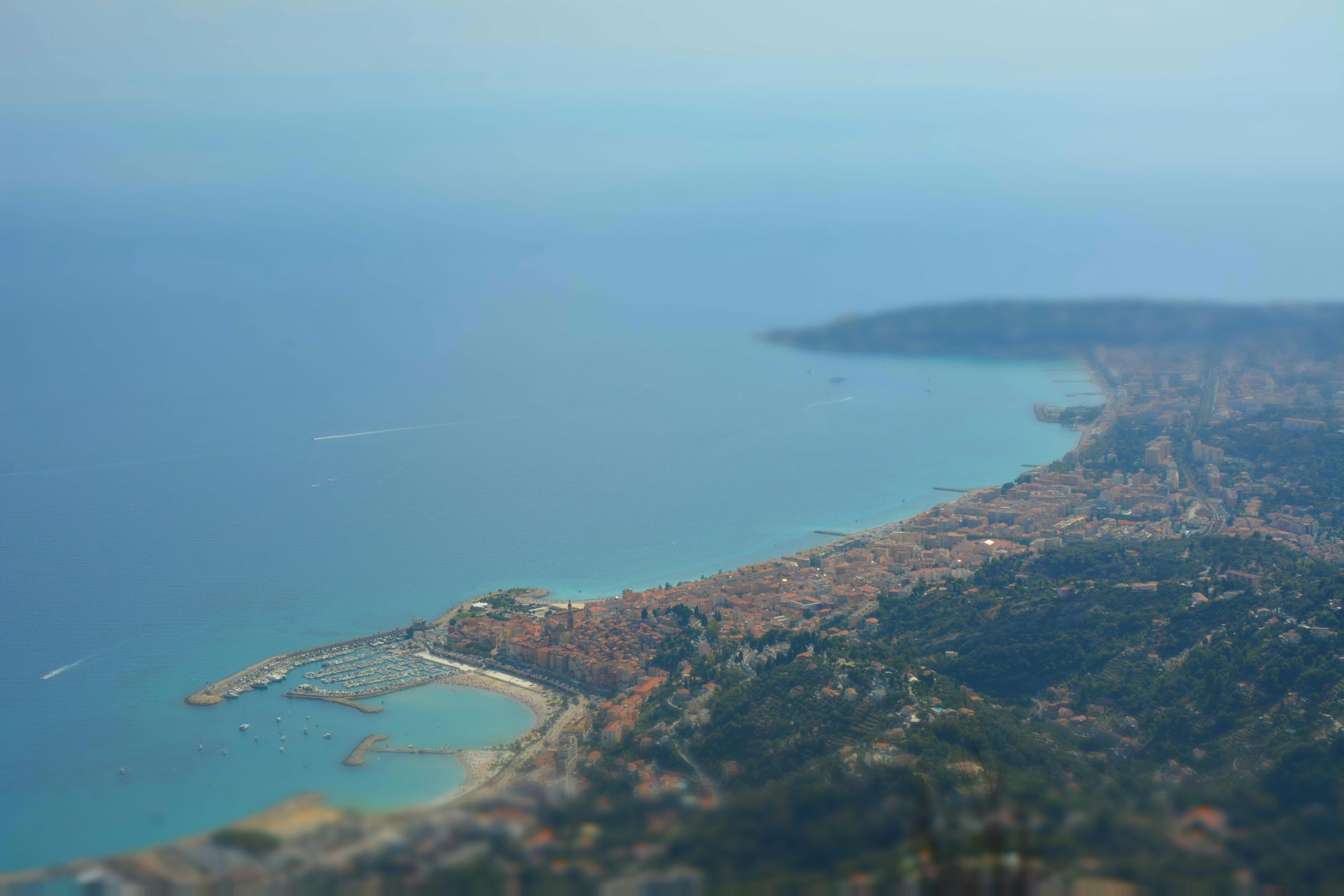 Stunning aerial view of the Menton coastline in Provence-Alpes-Côte d'Azur, featuring vivid blue waters and coastal cityscapes.