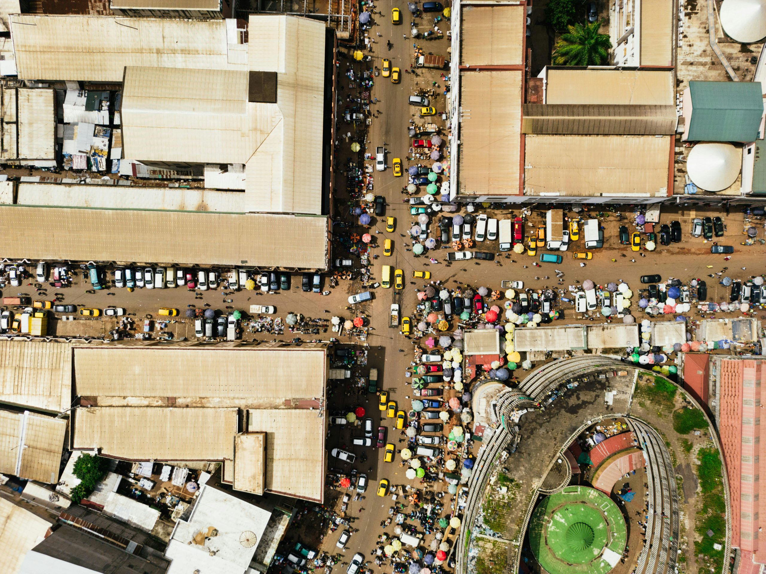 A bustling market street in Yaoundé, Cameroon, captured from above showing vibrant city life and architecture.