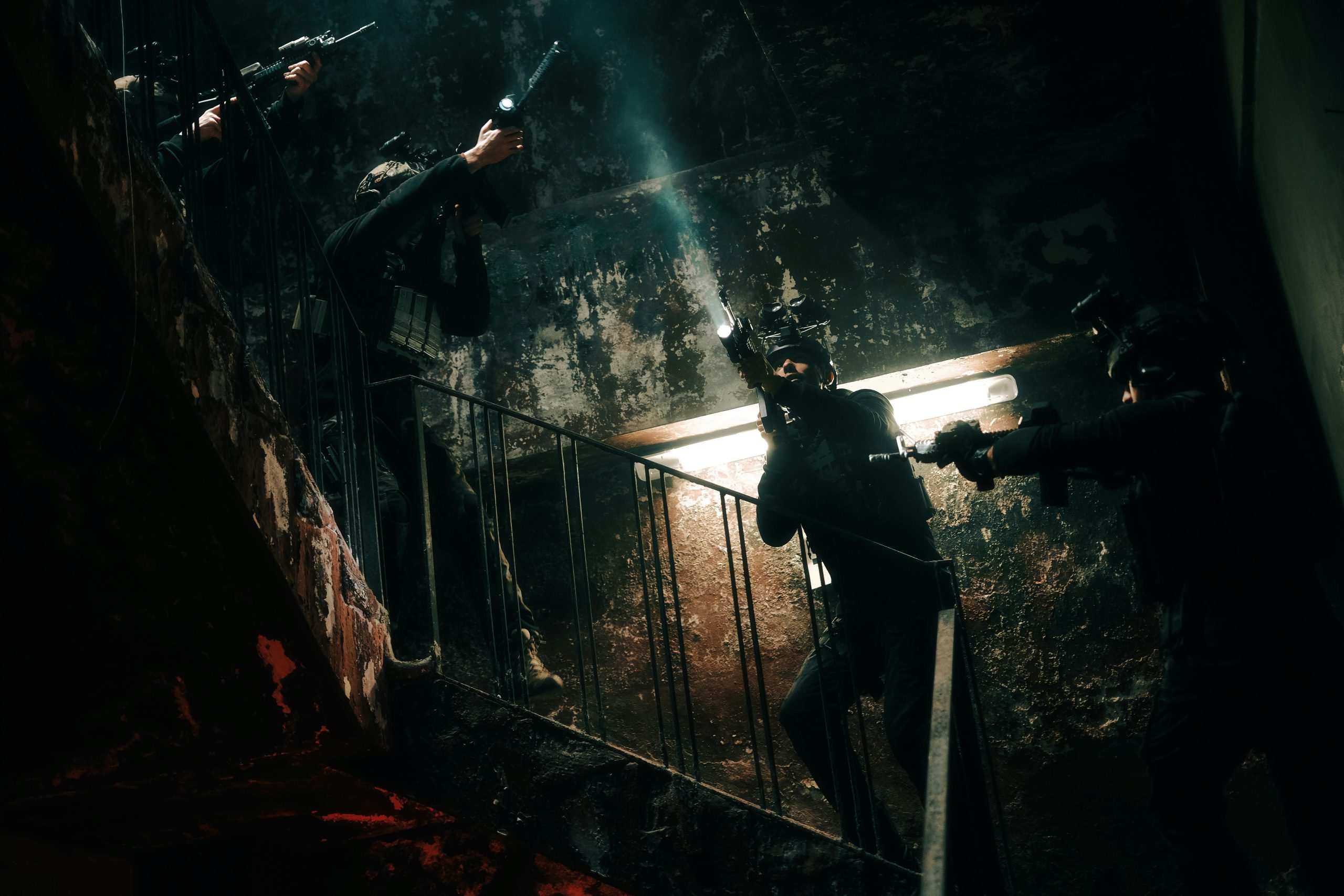 Special forces team conducting a tactical operation in a dimly lit, abandoned building.