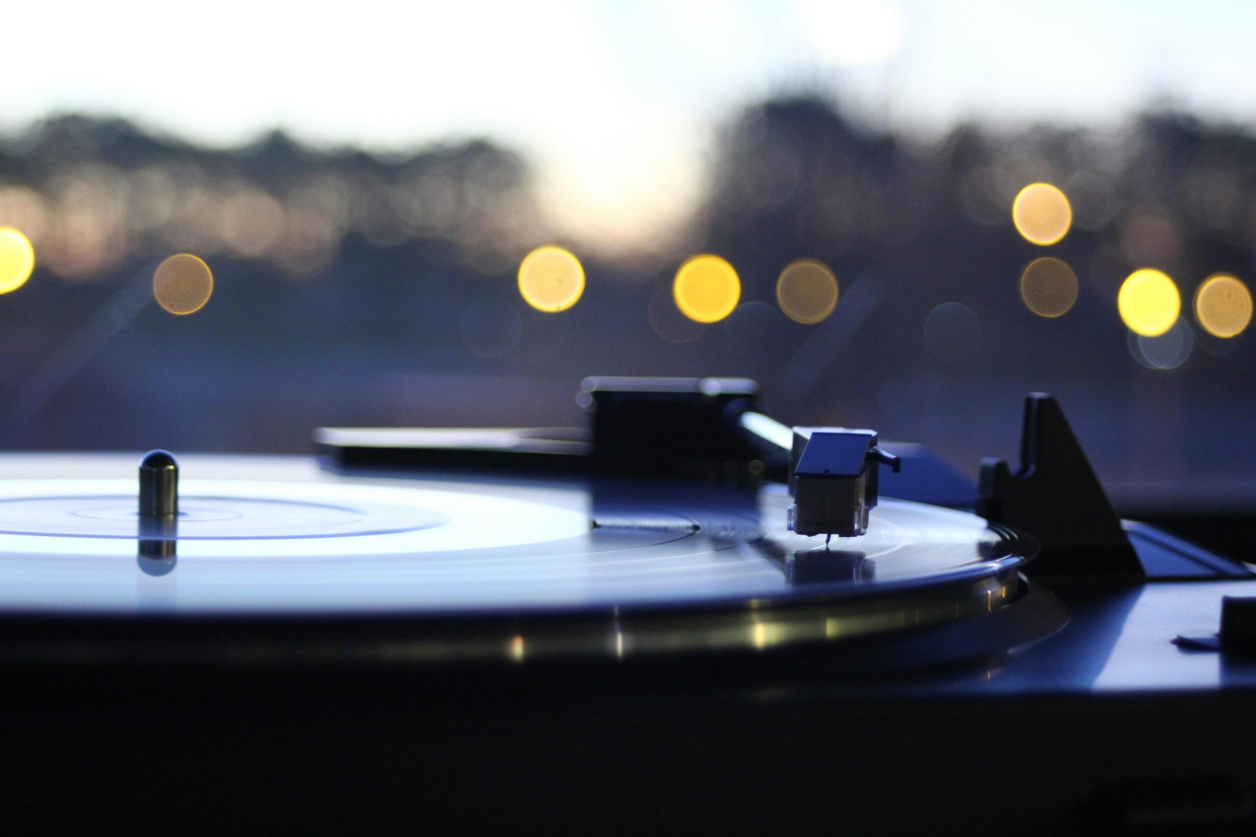 Close-up of a vintage turntable playing a vinyl record with a beautiful bokeh backdrop, capturing a nostalgic mood.