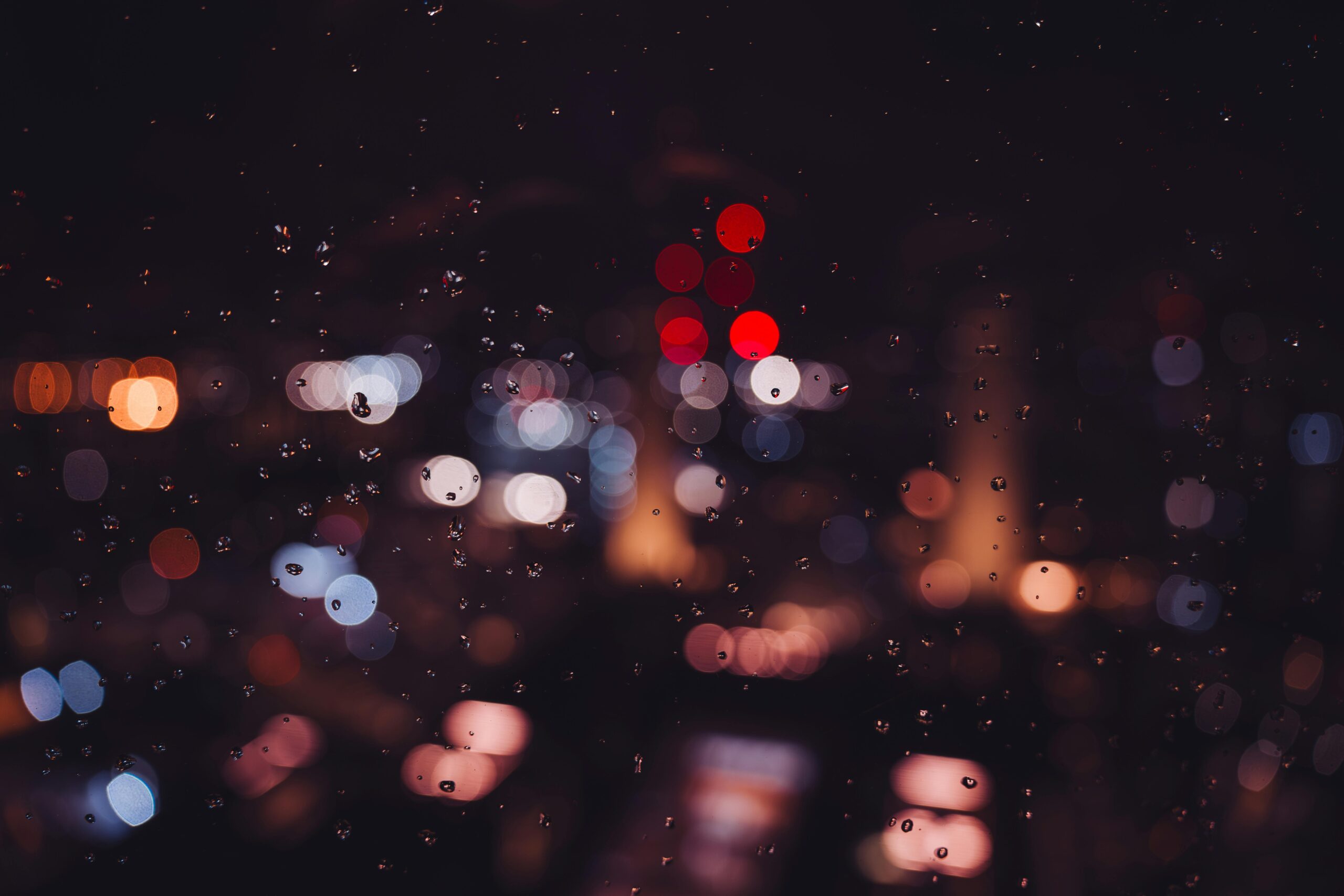 Bokeh city lights and raindrops on glass create a magical nighttime ambiance in London.