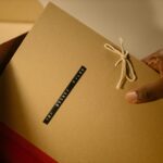 Close-up of hand holding top secret document folder in a box.