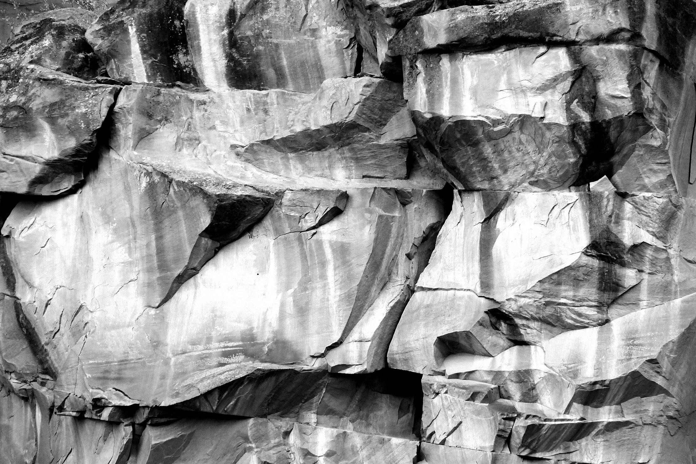 Bold, striking rock face with abstract textures in black and white, showcasing natural beauty.