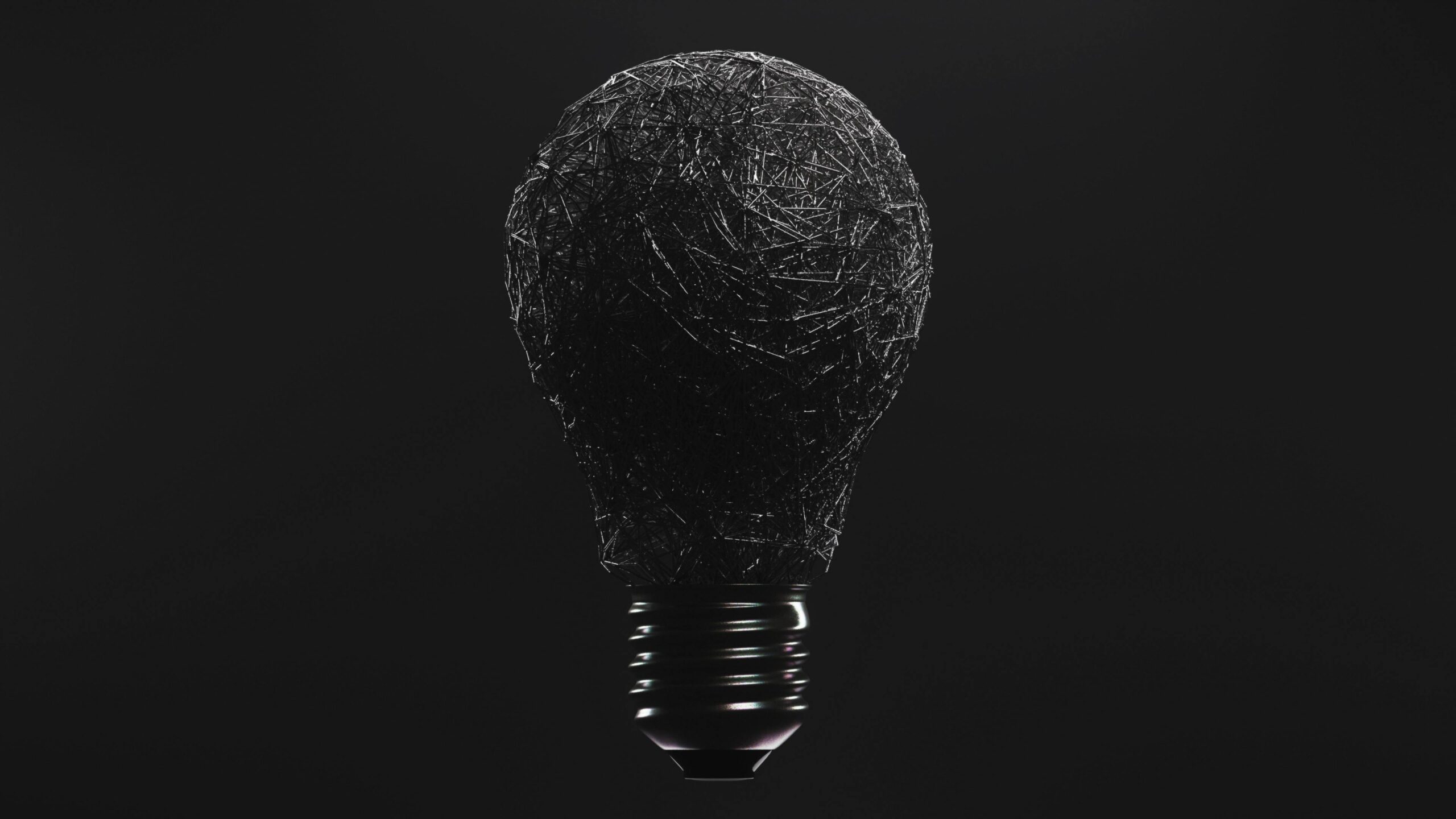 Conceptual image of a textured black light bulb against a dark background, symbolizing ideas and innovation.