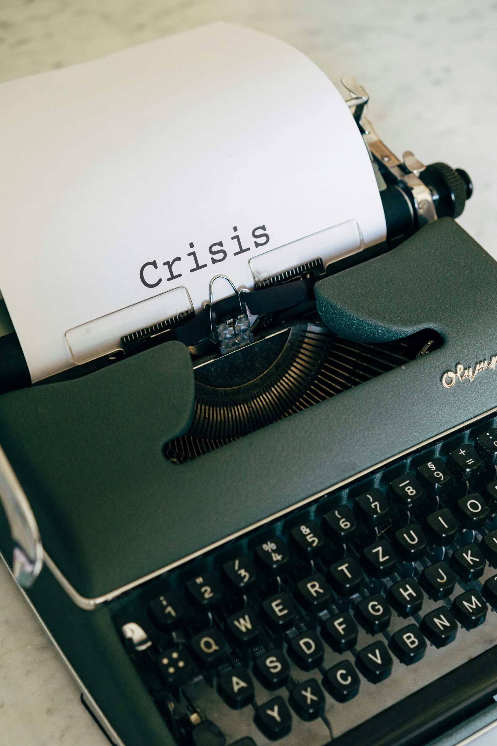 Close-up of a vintage typewriter with the word 'Crisis' typed on paper.