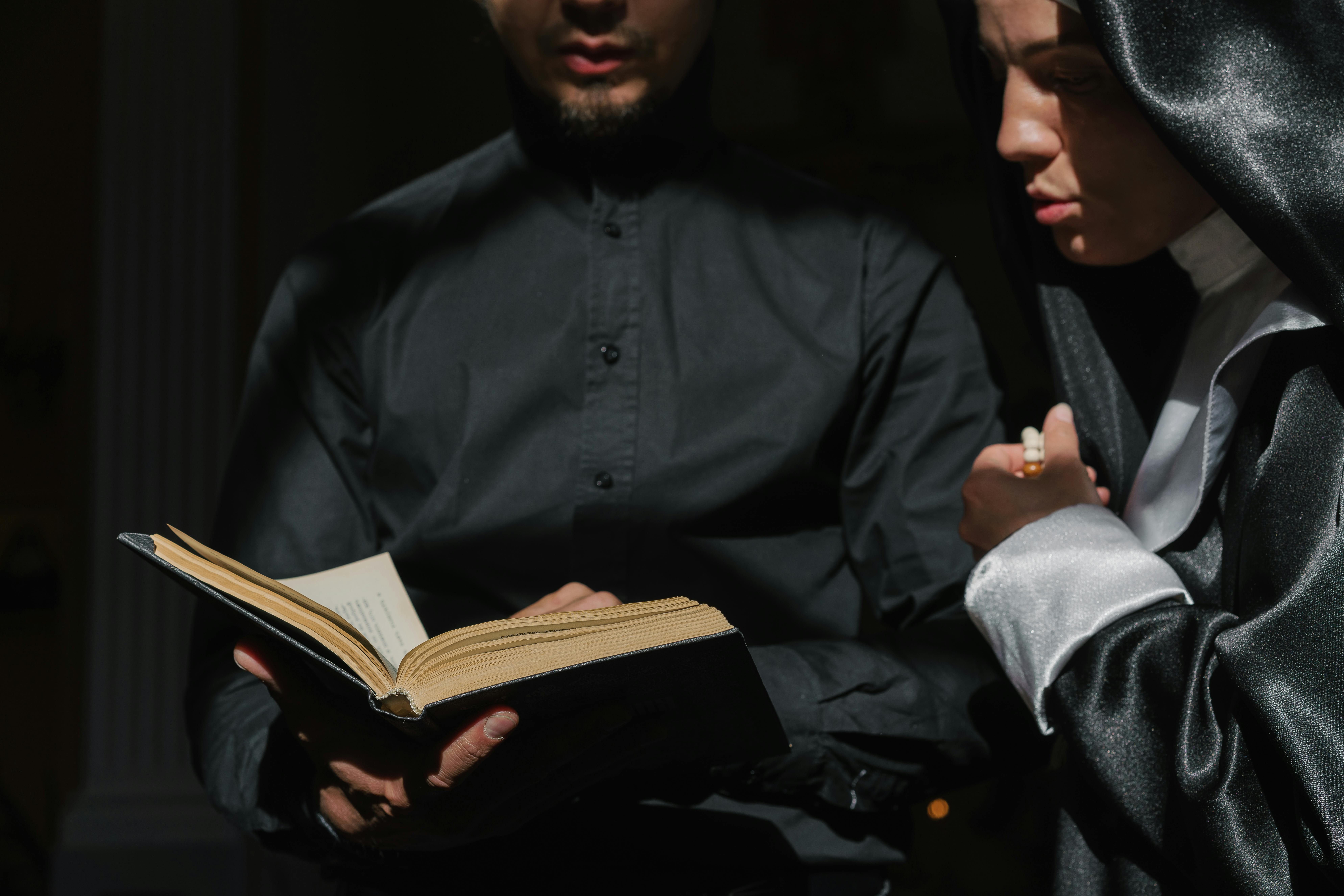 Priest and nun together studying a religious book, focusing on devotion and faith.
