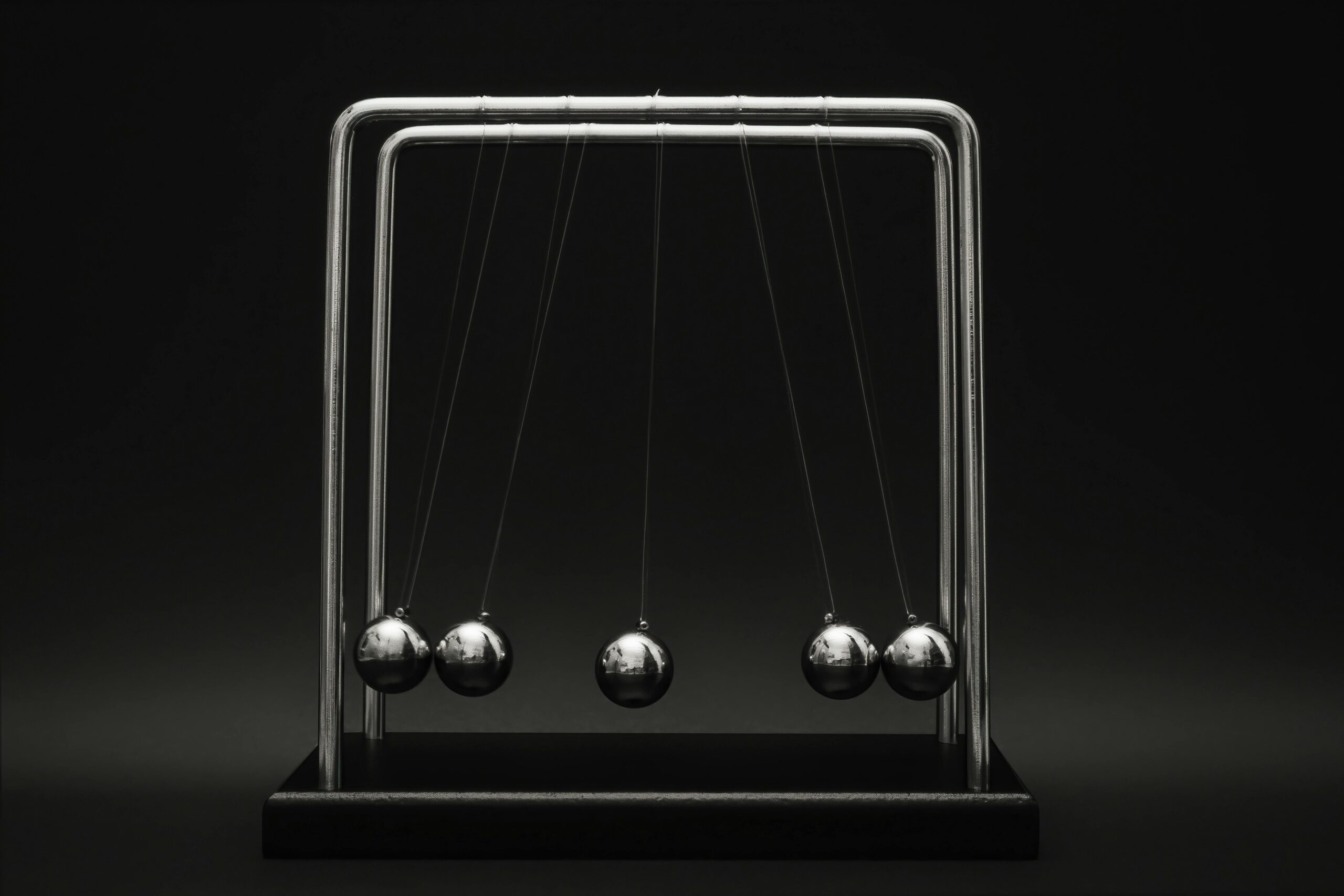 Newton's cradle for physics principles and motion study on a dark background.