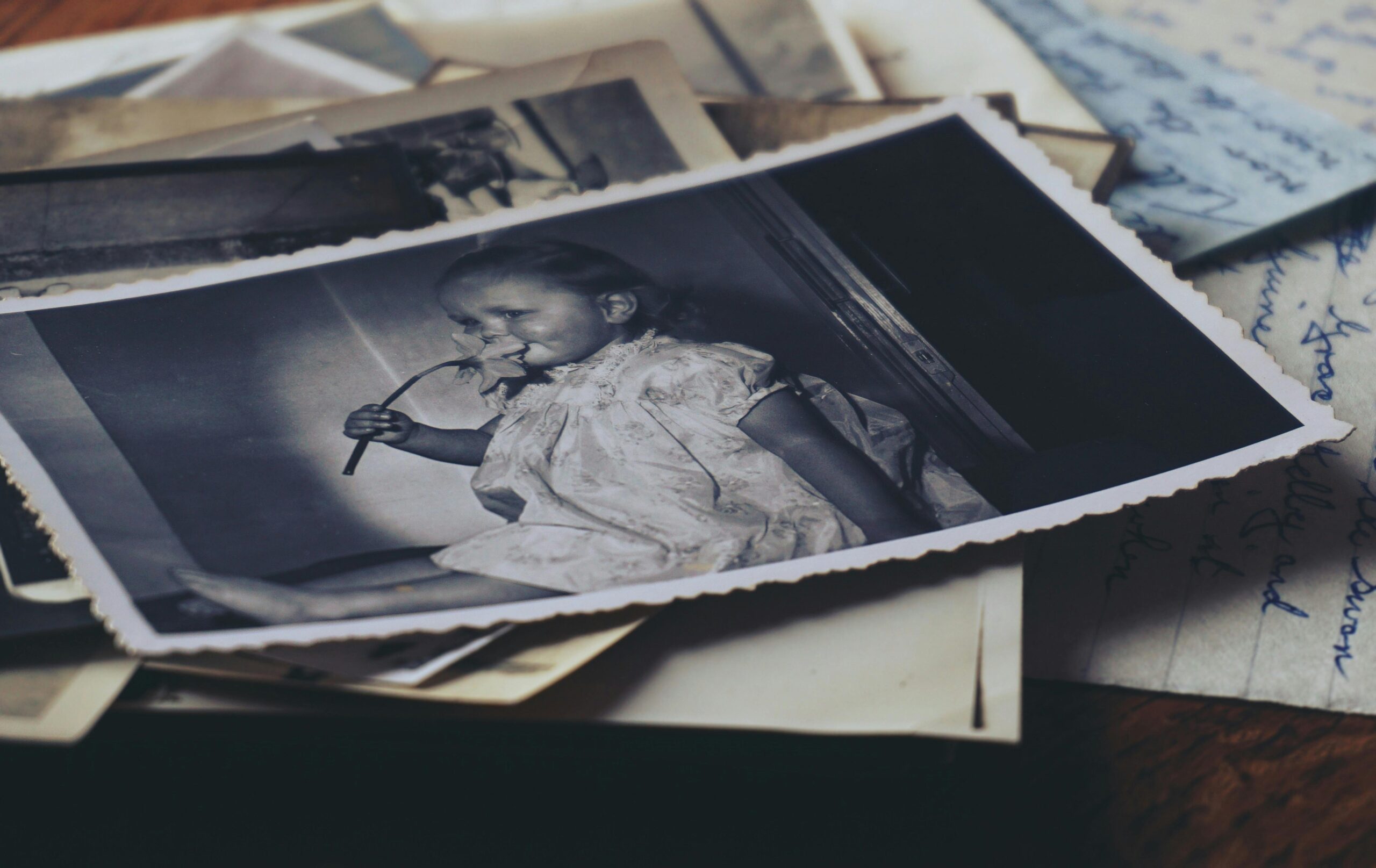 A nostalgic black and white photo of a child with old letters, evoking memories.